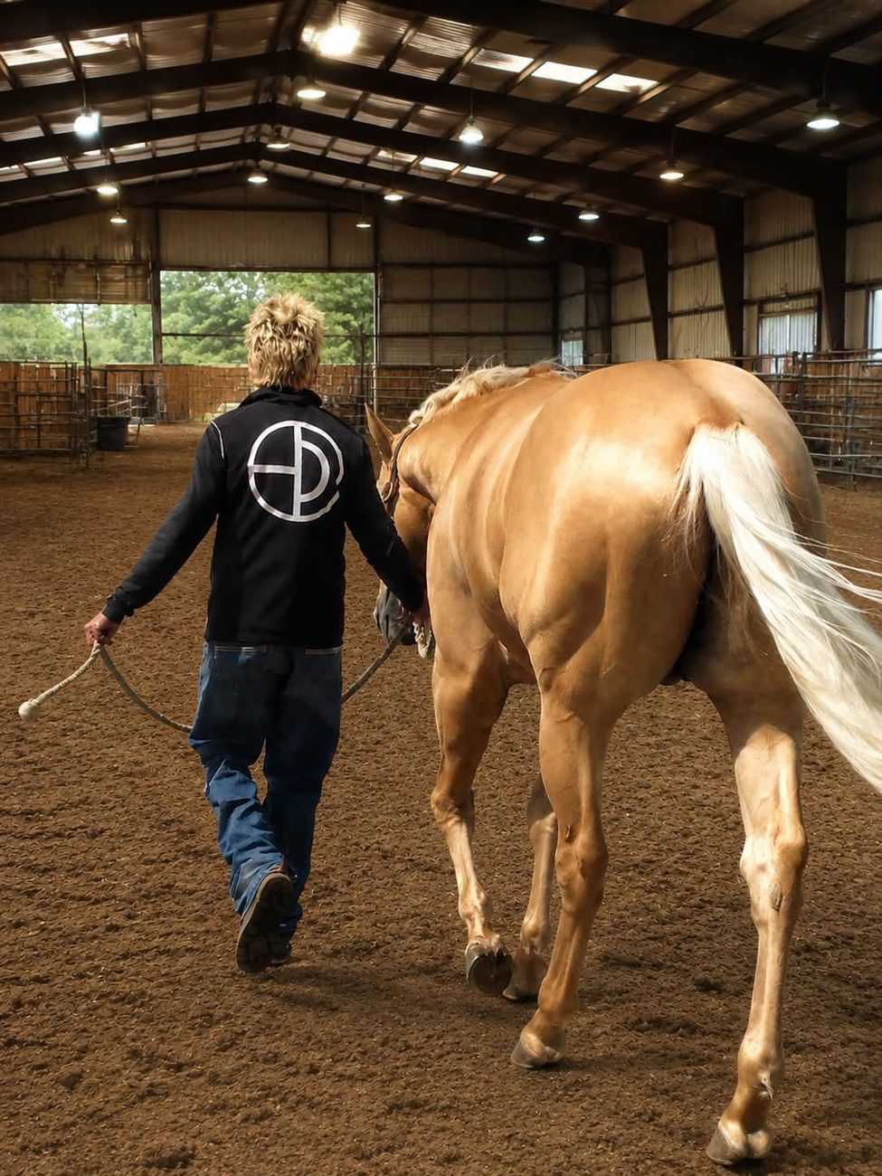 Paul Humphrey leading a palomino across an indoor arena