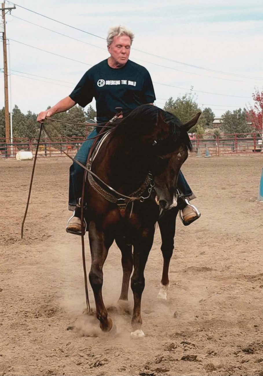 Paul Humphrey riding a bay in split reins, the horse softly bent to the inside